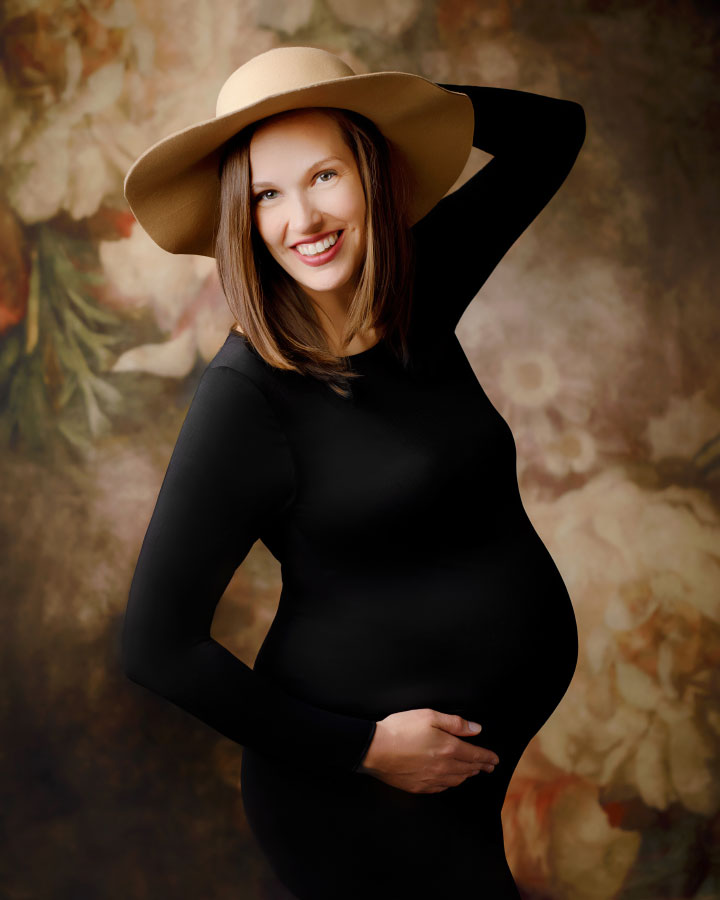 maternity photographer near Bremen, studio portrait with brown floral backdrop and hat