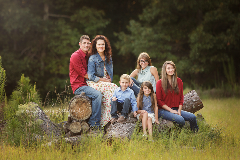 Family of 6 posed on logs by Carrollton family photographer