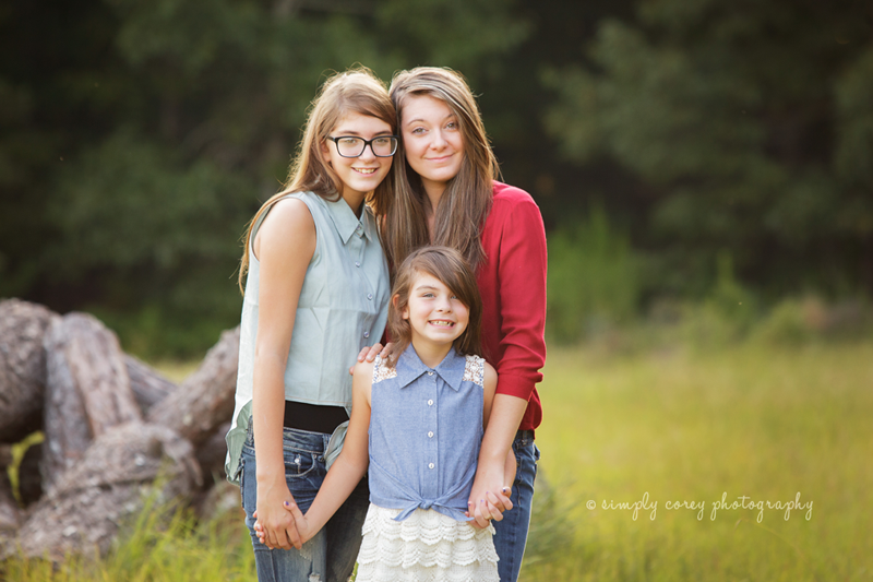 Sisters standing in a field by Atlanta family photographer, Simply Corey Photography
