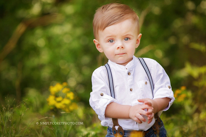 Atlanta baby photographer, toddler boy wearing suspenders in a field of flowers