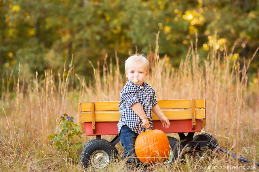 boy in a field with a wagon by Douglasville baby photographer