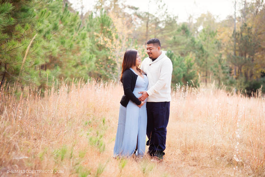mom and dad in a field by Atlanta maternity photographer