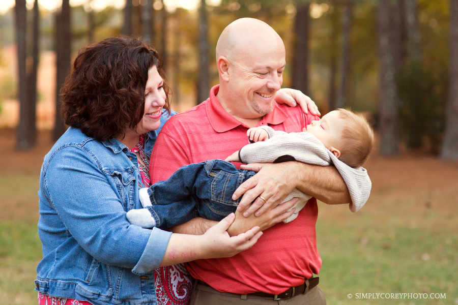 Mom and Dad holding a sleeping baby boy by Carrollton family photographer
