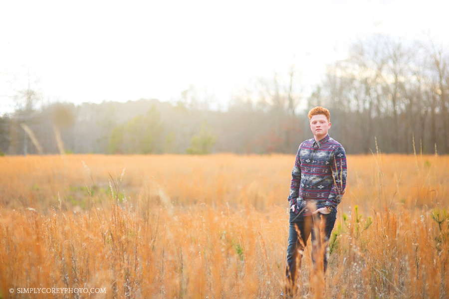 teen boy in a field by Newnan senior portrait photographer