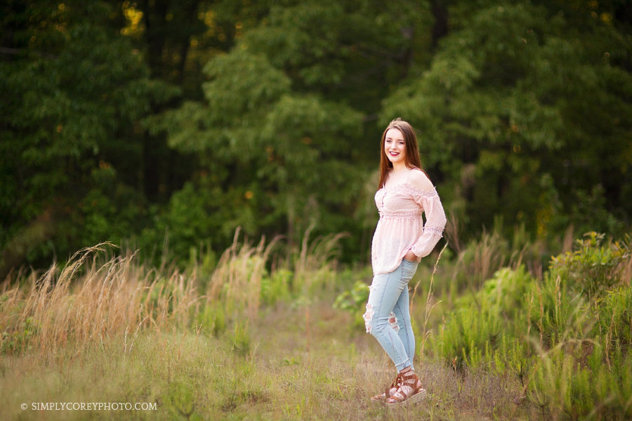 teen girl outside in a field by Newnan senior portrait photographer