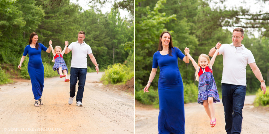expecting mom and dad swinging little girl on a dirt road by Atlanta family photographer