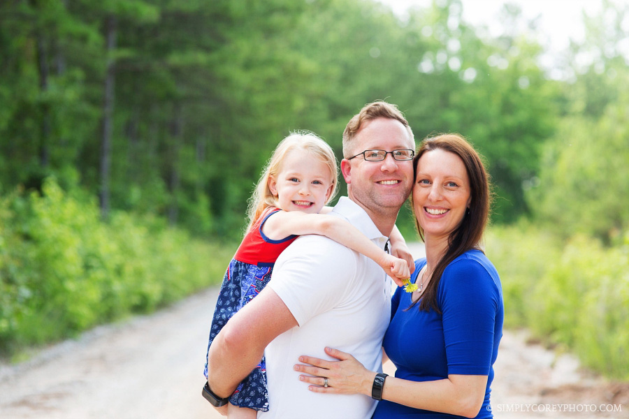 family of three outside by Carrollton family photographer