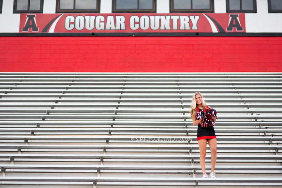 Alexander High School cheerleader on bleachers by Douglasville senior portrait photographer