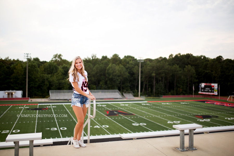 cheerleader overlooking Alexander High School football field by Douglasville senior portrait photographer