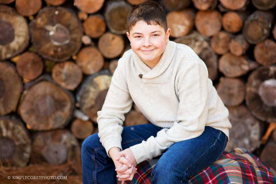 Carrollton children's photographer, tween boy near wood pile