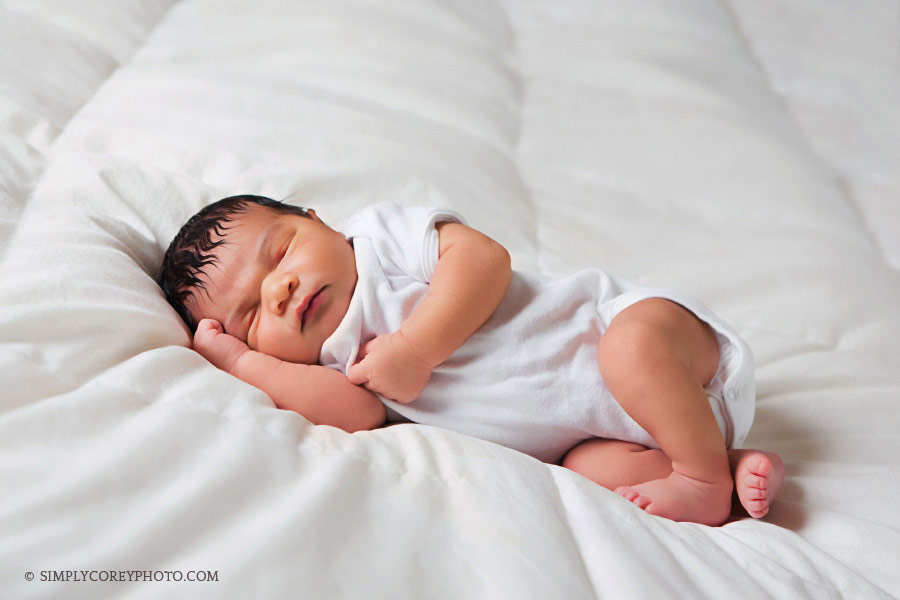 baby boy on a bed with a white blanket by Newnan newborn photographer