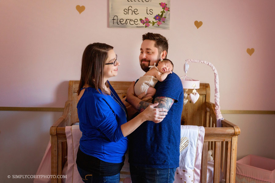Carrollton, Georgia family photographer, parents with newborn baby in the nursery