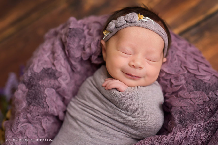 newborn photographer Atlanta, smiling baby girl with purple props
