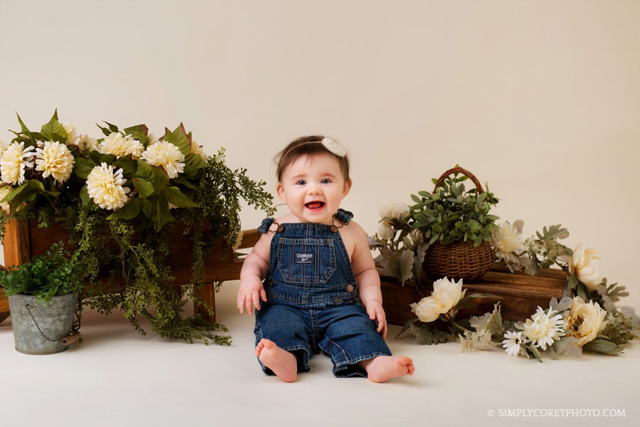 baby photographer Carrollton, girl in overalls with flowers in studio