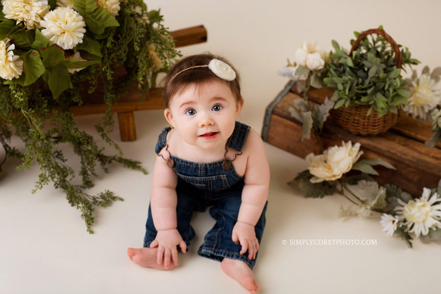 baby photographer Newnan, girl in overalls with flowers in studio