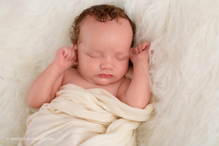 newborn photographer Newnan, baby boy with curly hair on fur