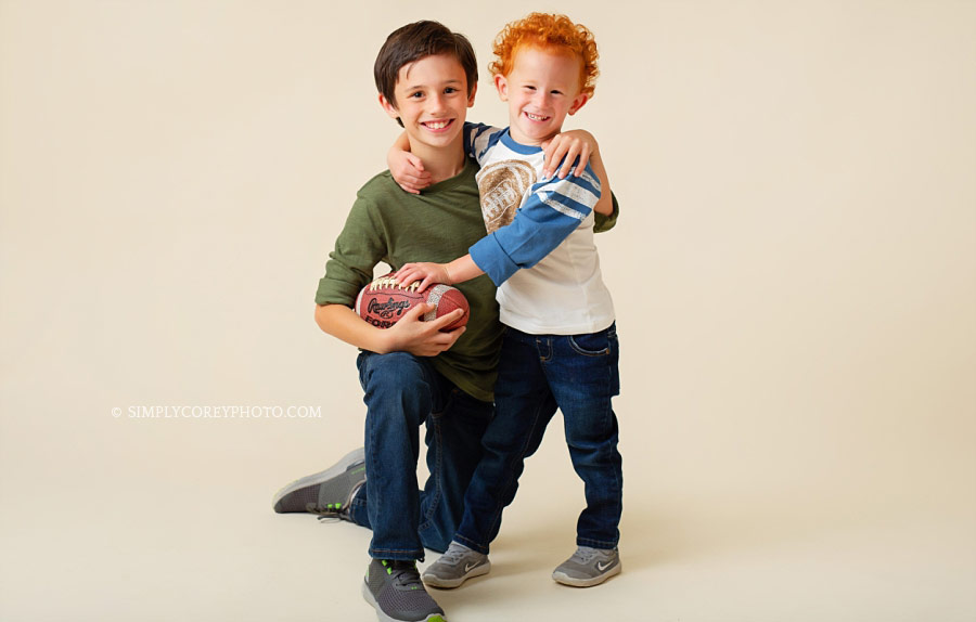 Newnan family photographer, two kids with a football in studio