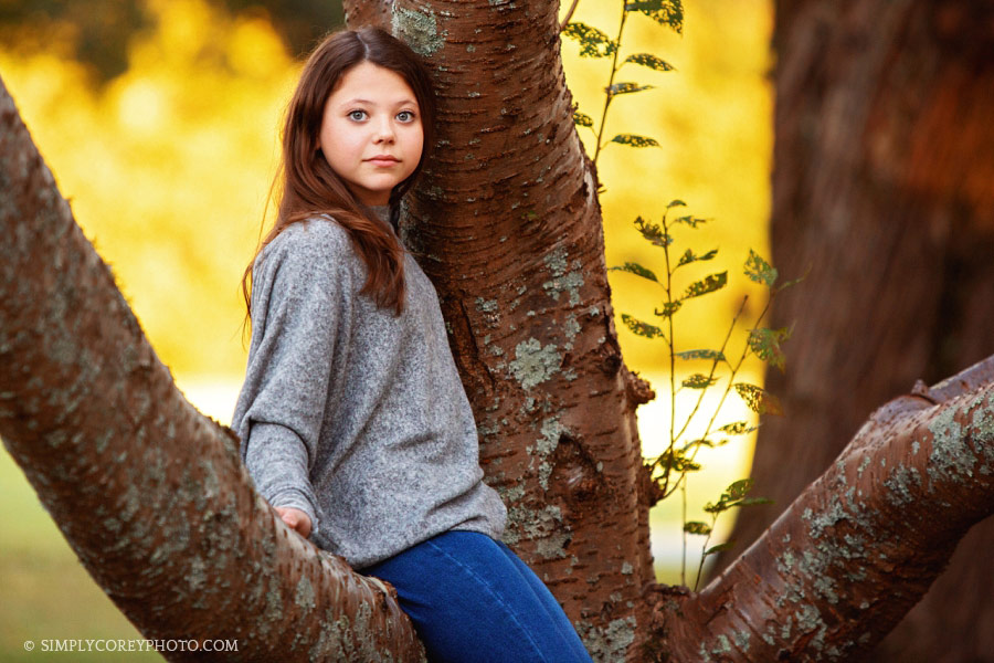 Atlanta photographer, tween girl outside sitting on a tree