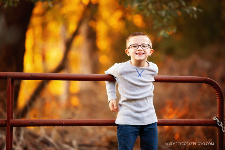 Douglasville children's photographer, boy in glasses on a country gate