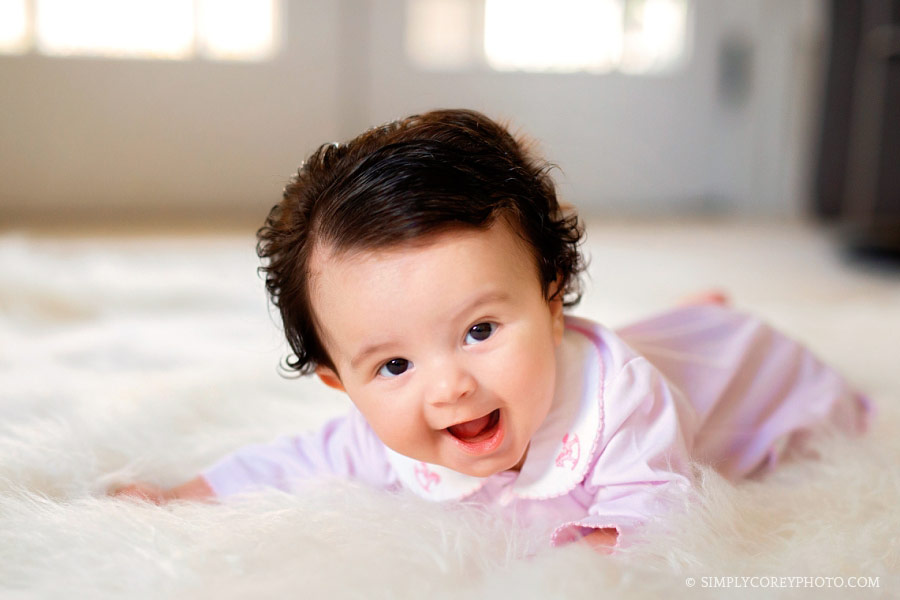 Douglasville baby photographer, girl smiling laying on nursery floor