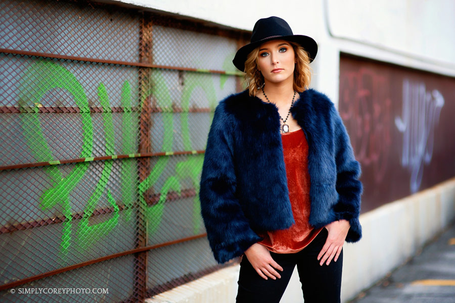 Atlanta senior portrait photographer, teen in fur jacket by graffiti wall