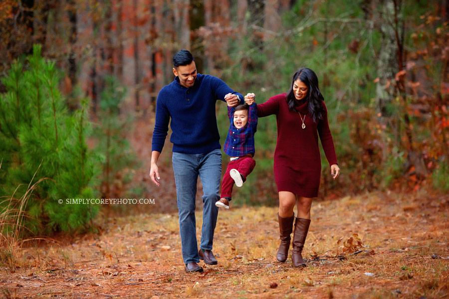 Villa Rica family photographer, parents swinging baby outside