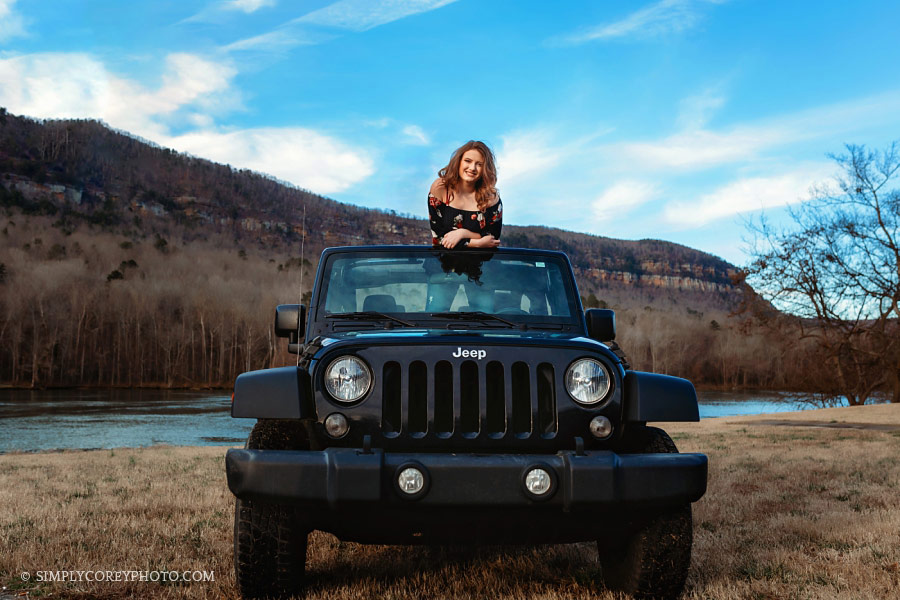 senior portrait photographer Douglasville, teen girl looking over top of a Jeep