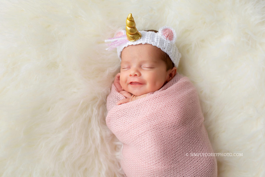 newborn photographer Newnan, baby smiling with a unicorn headband