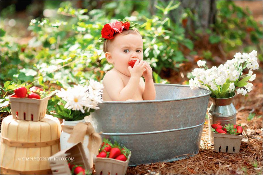 West Georgia baby photographer, baby girl eating strawberries during strawberry bath