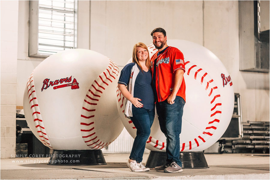 Villa Rica maternity photographer, couple with Atlanta Braves baseballs