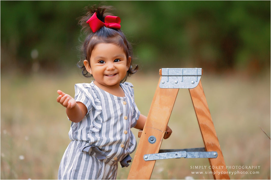 Atlanta baby photographer, girl outside in a field with a ladder