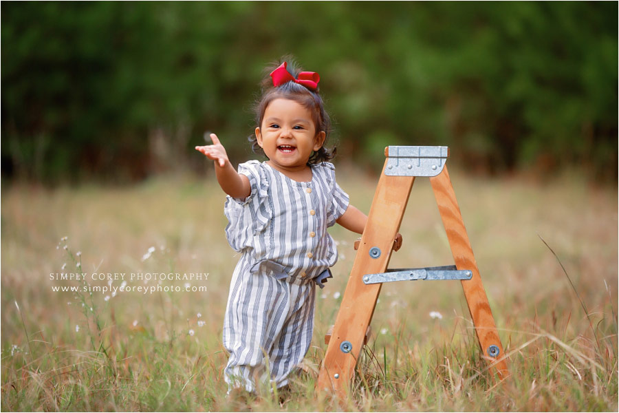 Newnan baby photographer, girl outside in field with ladder