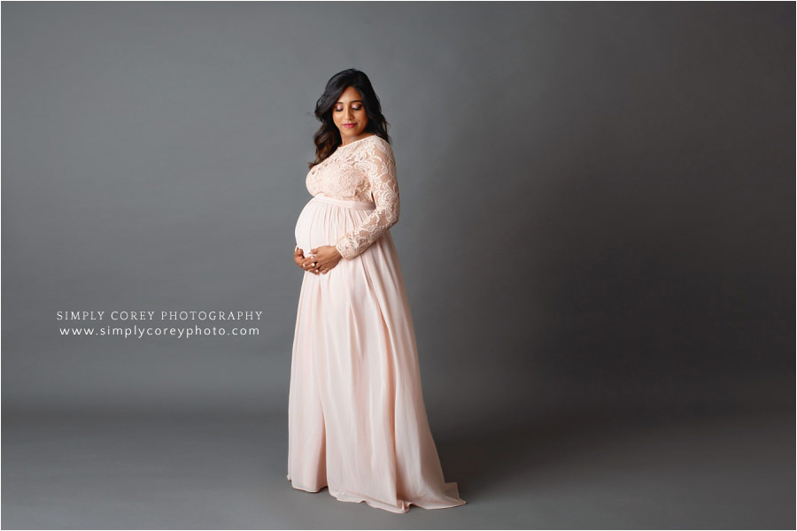 Carrollton maternity photographer, studio session in pink dress with gray backdrop