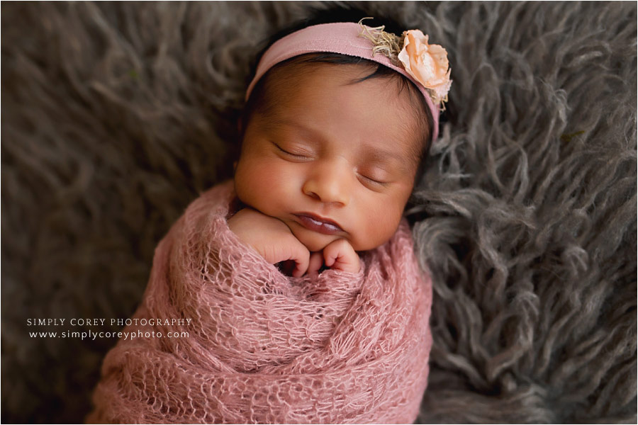 newborn photographer near Atlanta, baby in pink wrap on fur
