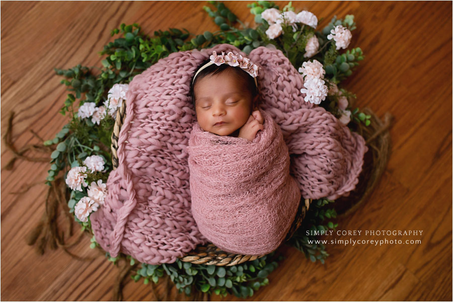 newborn photographer near Carrollton, GA; baby with pink blanket and flowers