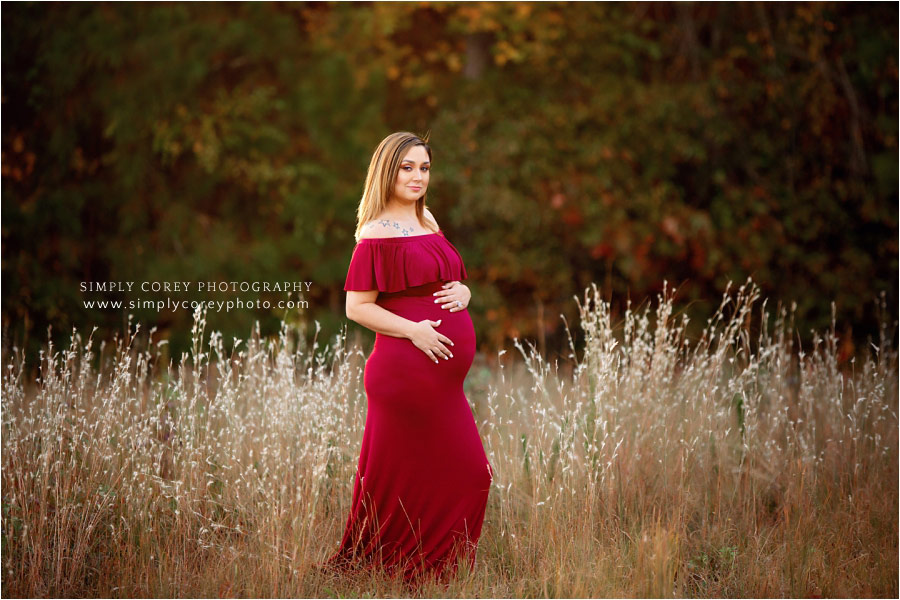 Douglasville maternity photographer, mom in red dress outside in field
