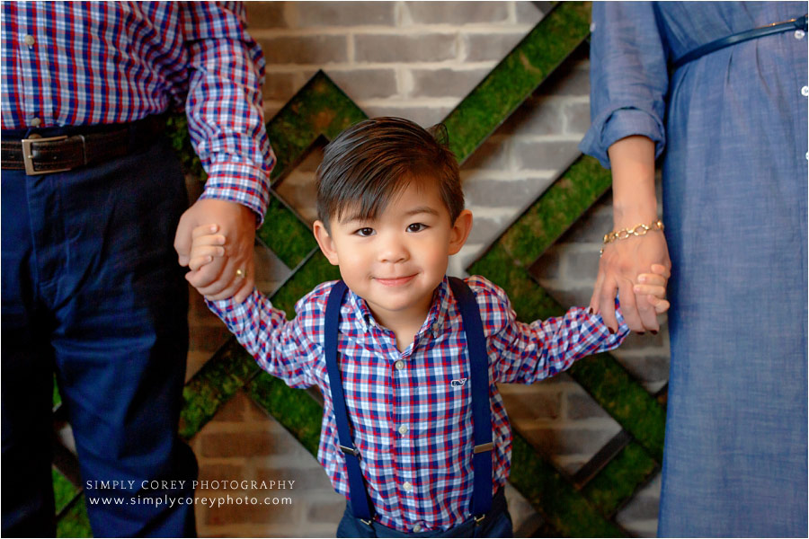 Newnan family photographer, child holding parents' hands