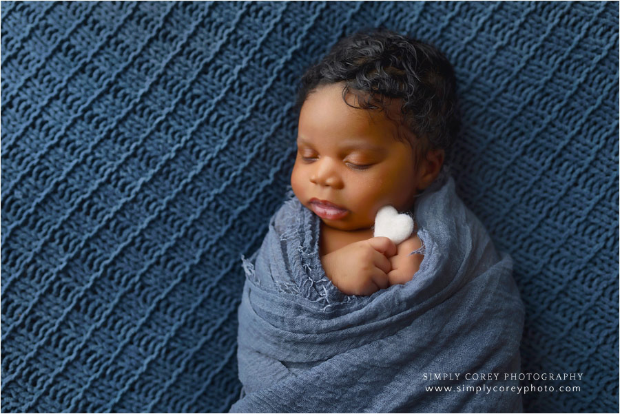 Newnan newborn photographer, baby boy in blue holding heart