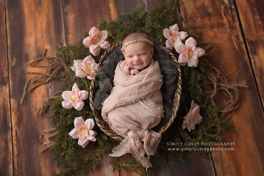 newborn photographer near Atlanta, smiling baby in basket with flowers