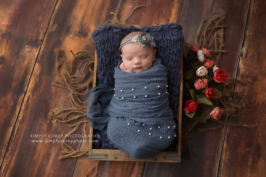 newborn photographer near Douglasville, baby girl in blue wrap with flowers