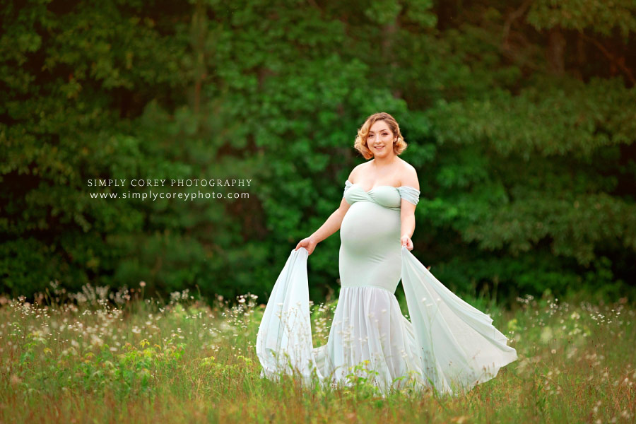 maternity photographer near Carrollton, GA; outside in field in a green flowy dress