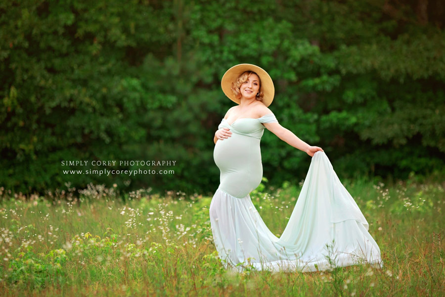 maternity photographer near Newnan, outside in a flowy dress and floppy hat