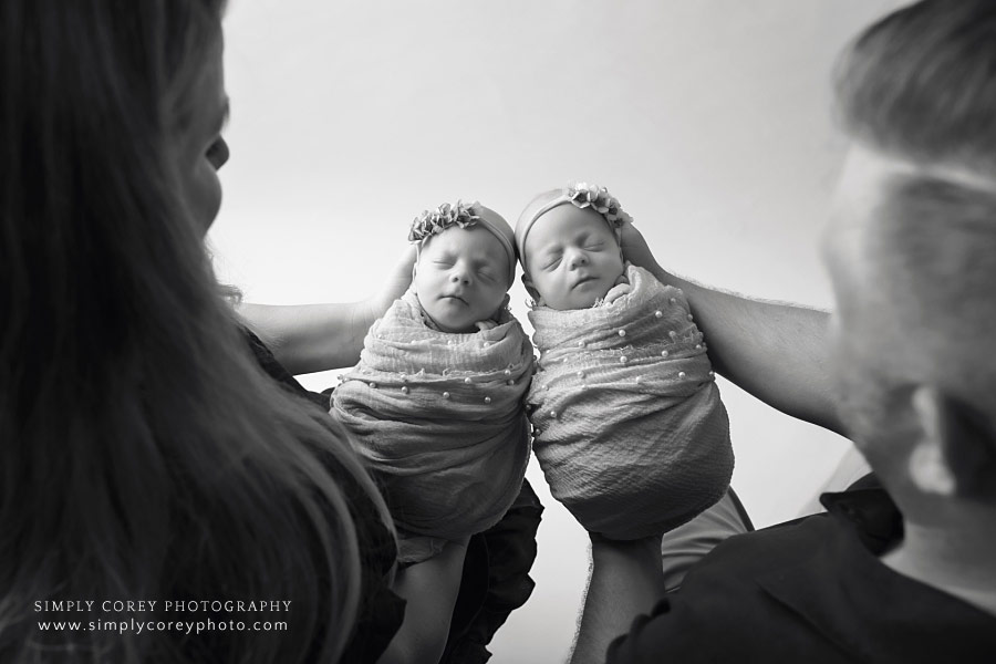 Atlanta family photographer, parents holding twin newborn babies in black and white