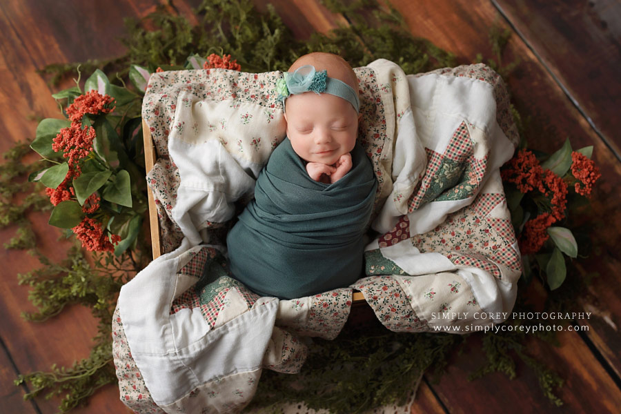 Atlanta newborn photographer, smiling baby girl in teal on a quilt