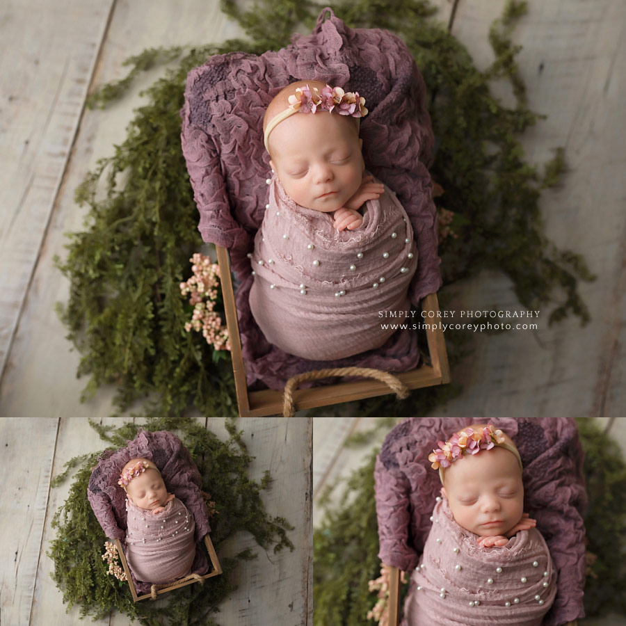 newborn photographer near Carrollton, GA; baby in purple wrap with greenery