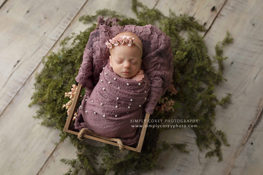newborn photographer near Newnan, baby in purple pearl wrap and wood box