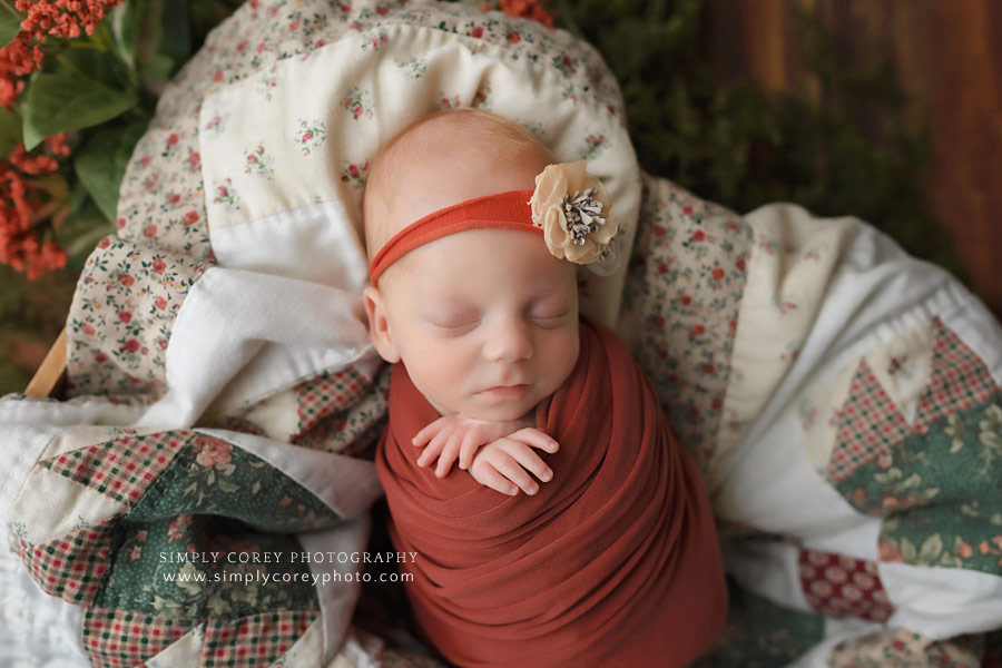 newborn photographer in West Georgia, baby girl in orange with a quilt