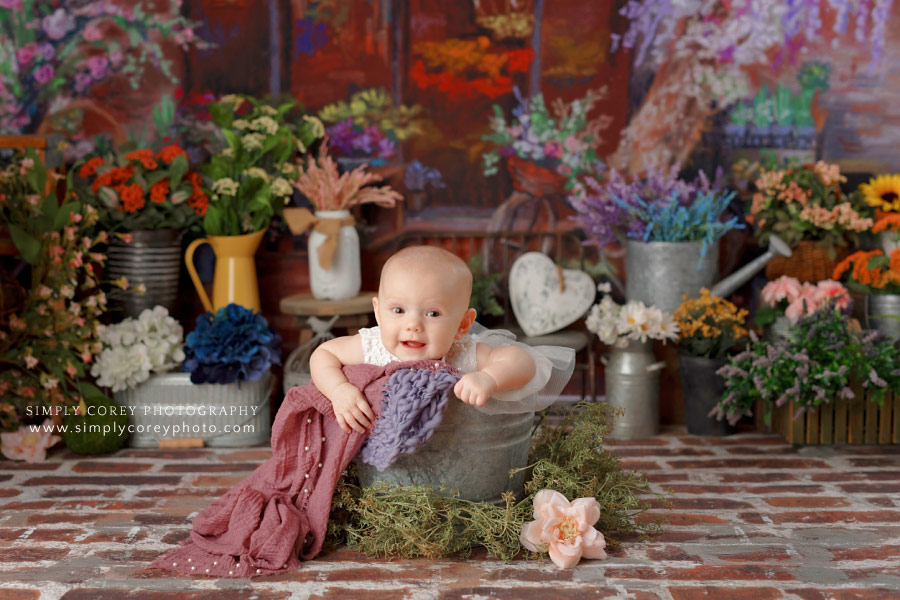 baby photographer near Atlanta, 5 month old in bucket with flowers in studio
