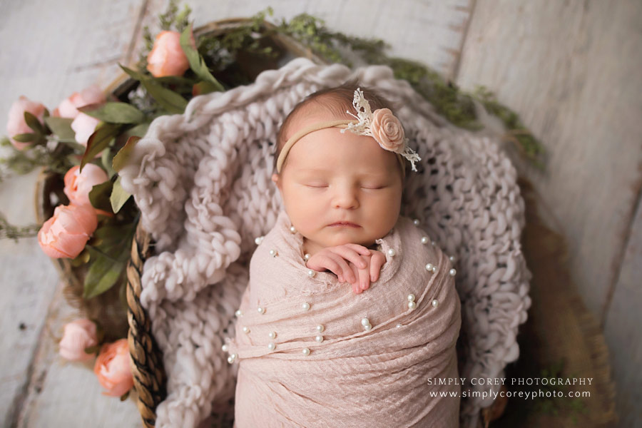 newborn photographer near Carrollton, GA; baby with flowers and pearl layer