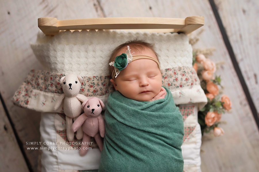 Newnan newborn photographer; baby girl sleeping on bed with teddy bears